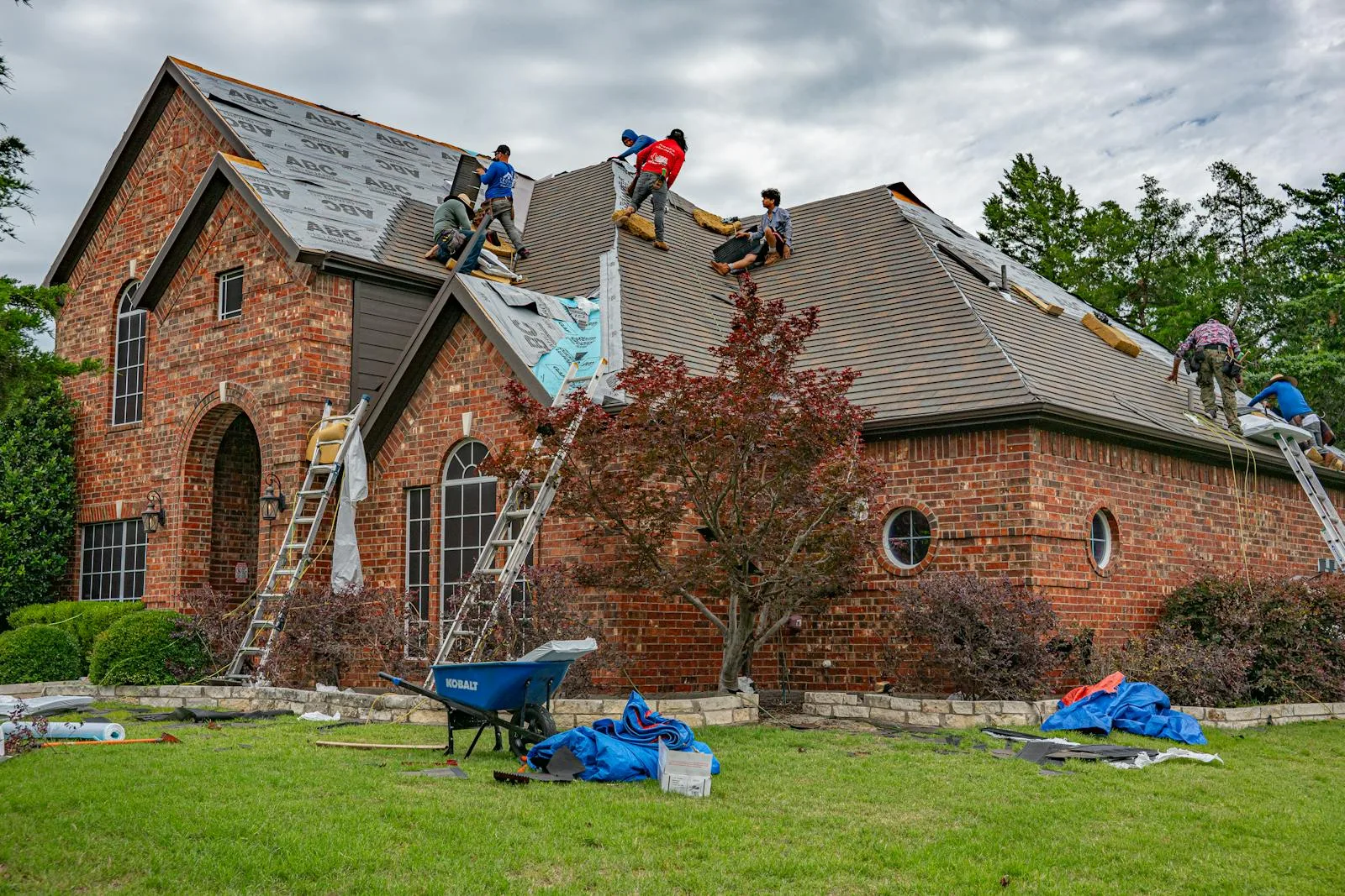 Roofing crew renovating the roof of a brick house